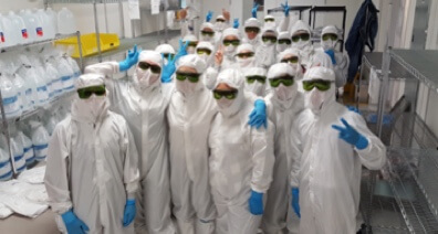 Group photo of people wearing lab safety overalls