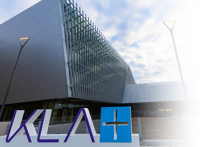 The KLA Logo with the Ann Arbor facility in the background