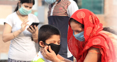 A person putting a mask on a child.