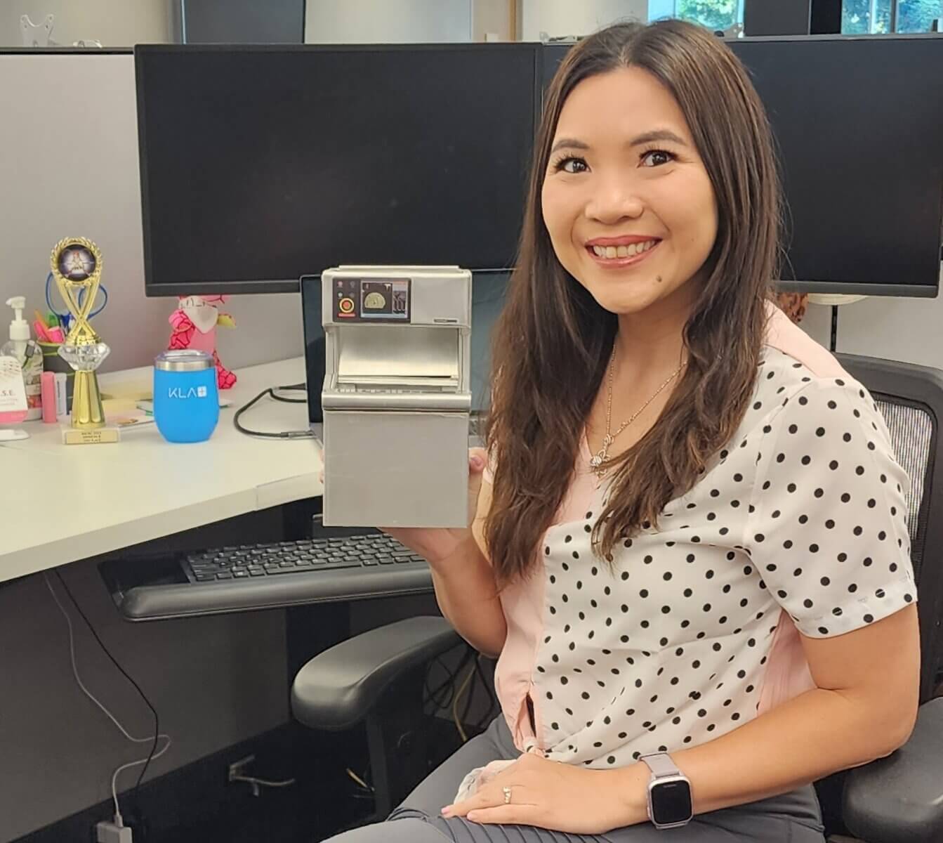 Elizabeth Nio holds a prototype model of an older product.