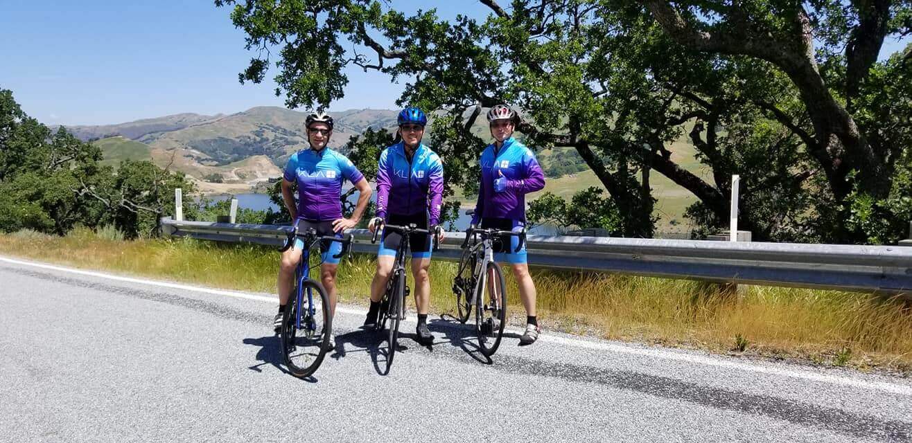 KLA employees pose by their bikes outdoors while supporting KLA’s annual Bike to Wherever Day, 2021.   