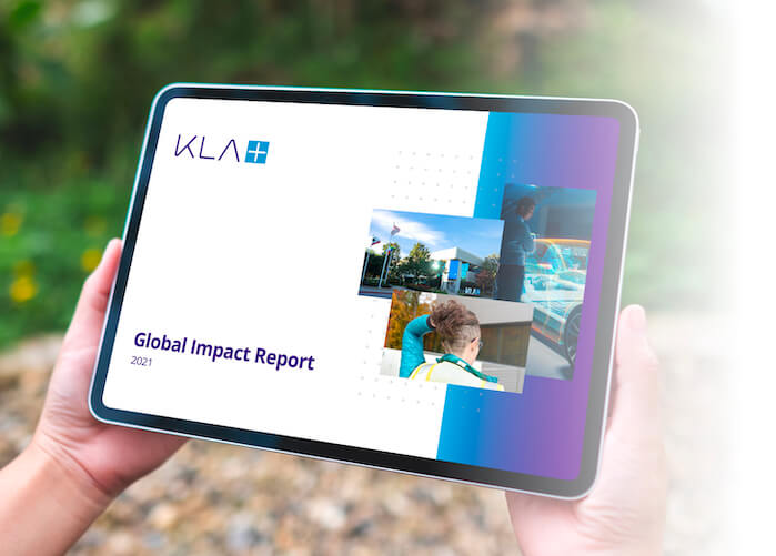 A person holding a tablet that is displaying the KLA global impact report.