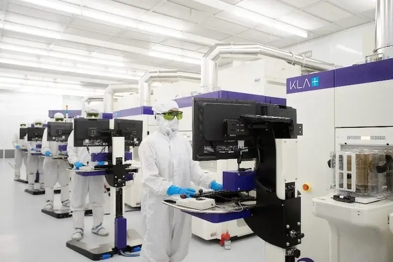 KLA employees working with wafer processing tools in a cleanroom